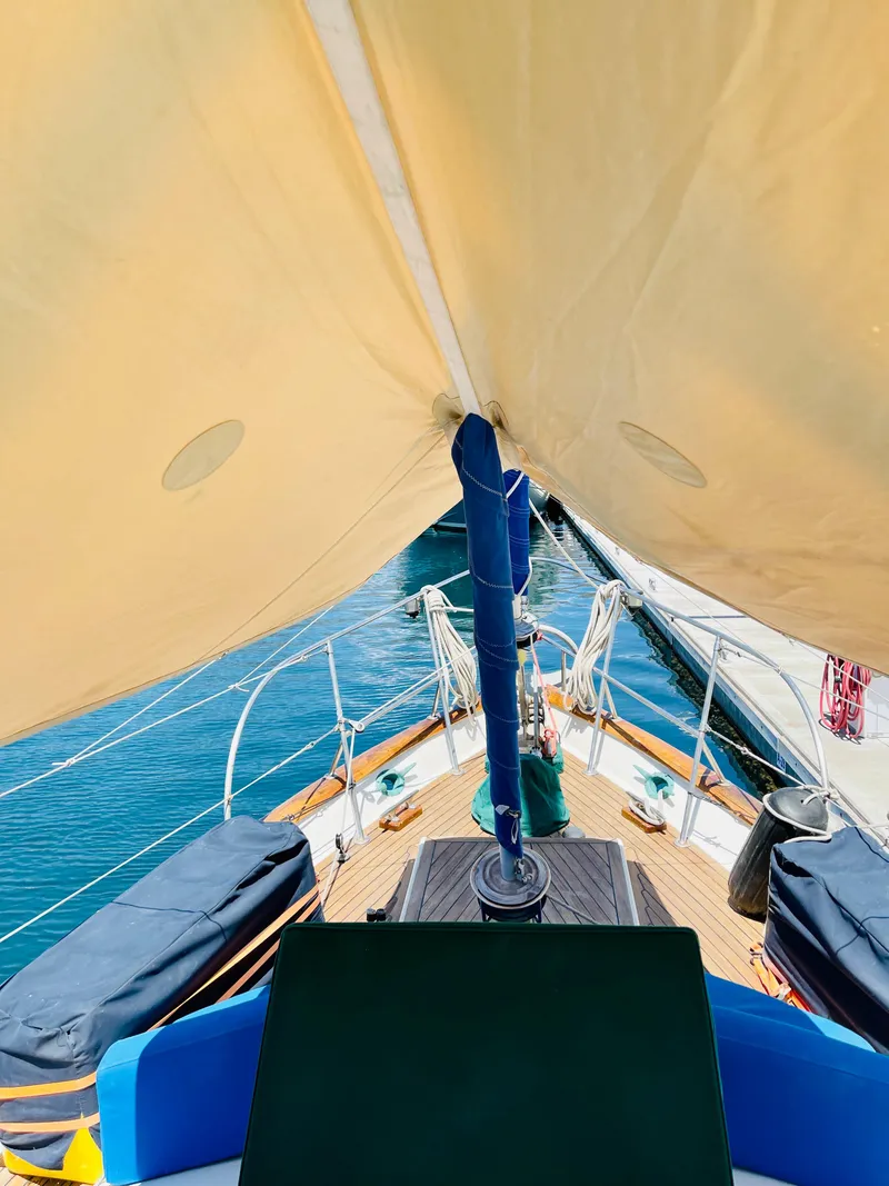 Slide: The Image of 1977 Aleutian 51 sailboat deck view with sails and ocean backdrop. - 12