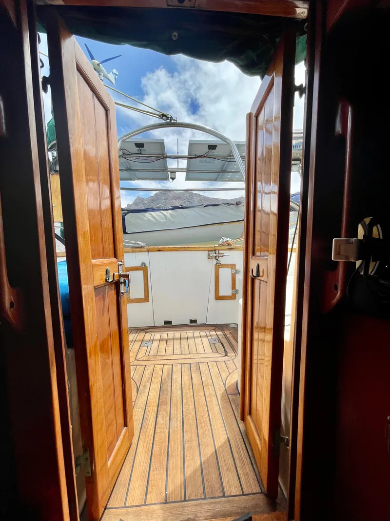 Slide: The Image of Wooden doors open to a sunlit deck on a 1977 Aleutian 51 yacht. - 14