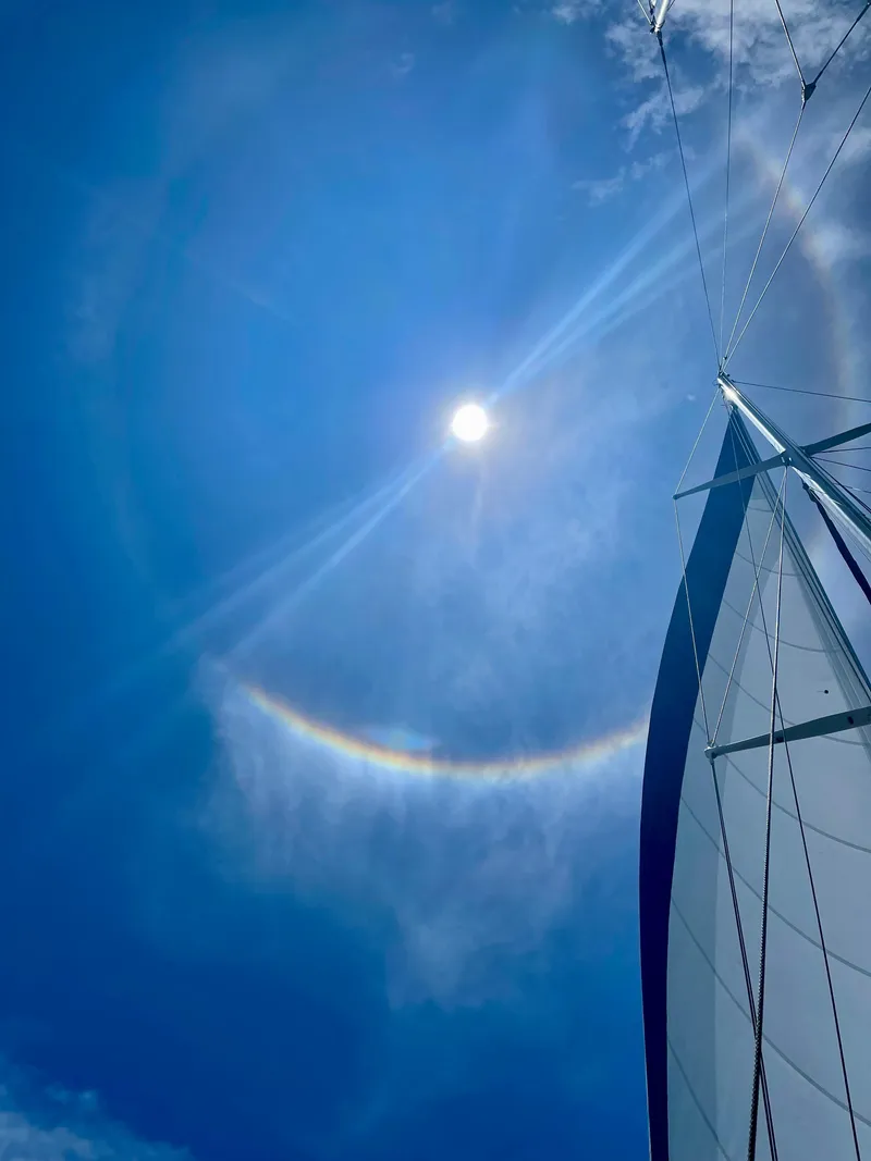 Slide: The Image of Sailboat Aleutian 51 under a bright sun halo in clear blue sky. - 23