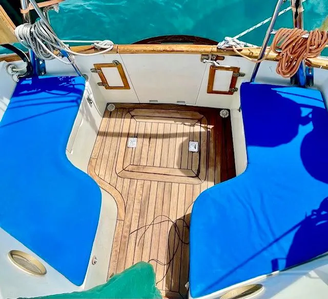 Slide: The Image of Cockpit of 1977 Aleutian 51 sailboat with blue cushions and teak flooring. - 29