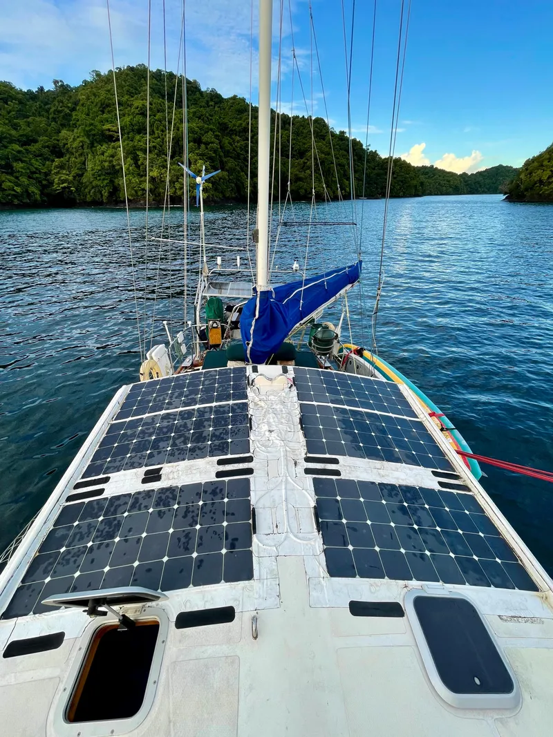 Slide: The Image of Sailboat with solar panels on deck, Aleutian 51, 1977, anchored in scenic tropical waters. - 4