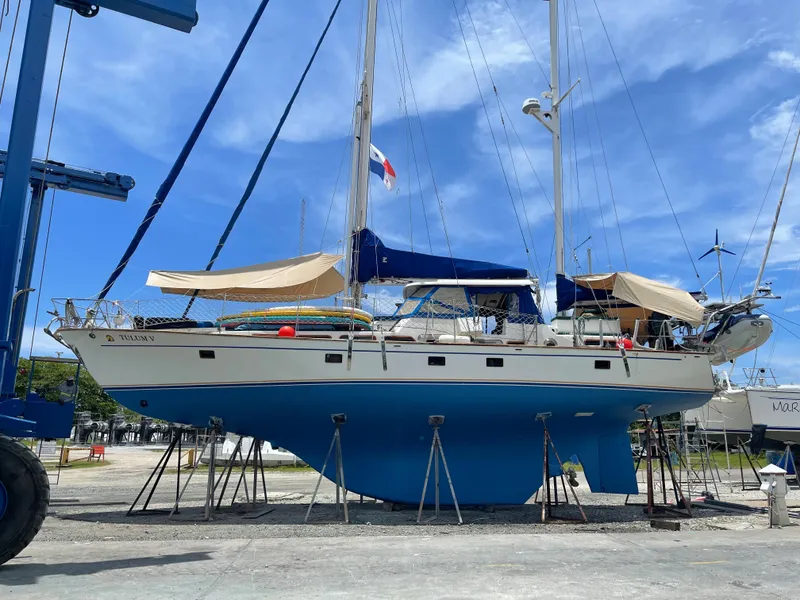 Slide: The Image of 1977 Aleutian 51 sailboat on stands, blue hull, clear sky background. - 8