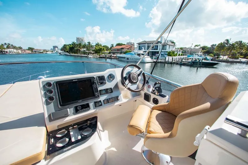 Slide: The Image of Flybridge helm of 2015 Absolute 56 FLY yacht with luxurious seating and waterfront view. - 12