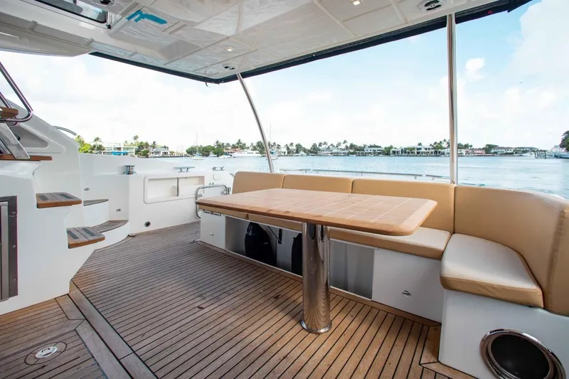 Slide: The Image of Luxurious 2015 Absolute 56 FLY yacht deck with seating and table, overlooking serene waters. - 17
