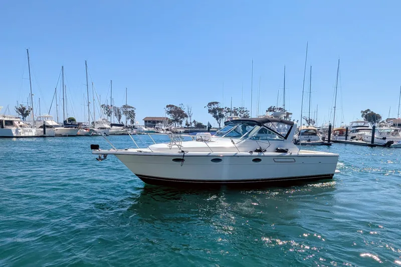 Slide: The Image of 1995 Tiara Yachts 3100 Open cruising in a sunny marina. - 11