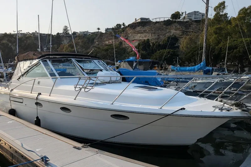 Slide: The Image of 1995 Tiara Yachts 3100 Open docked in a marina, surrounded by other boats. - 16