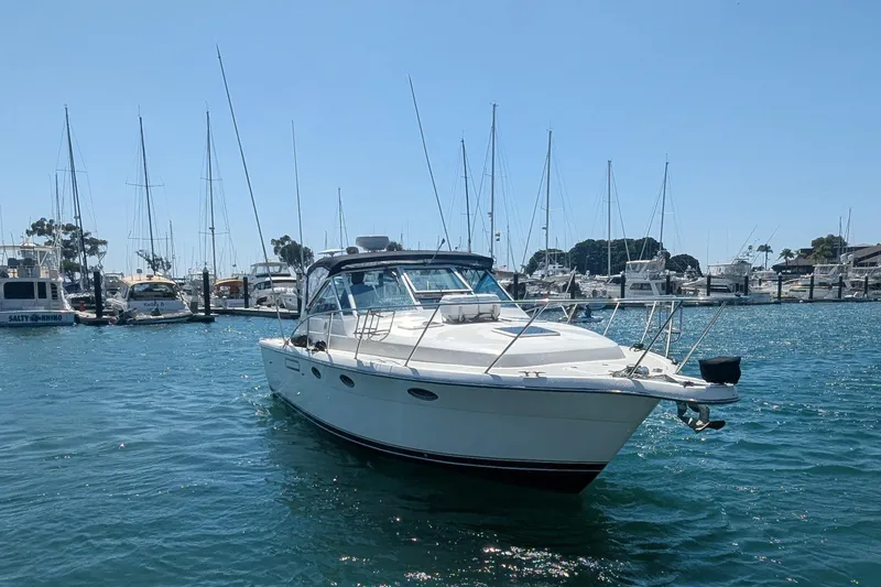 Slide: The Image of 1995 Tiara Yachts 3100 Open in marina, surrounded by sailboats under clear blue sky. - 17