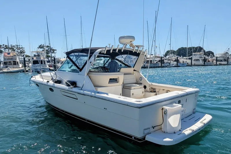 Slide: The Image of 1995 Tiara Yachts 3100 Open boat docked in a marina under clear blue skies. - 18