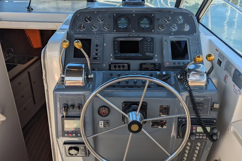 Slide: The Image of 1995 Tiara Yachts 3100 Open helm with steering wheel and navigation controls. - 24