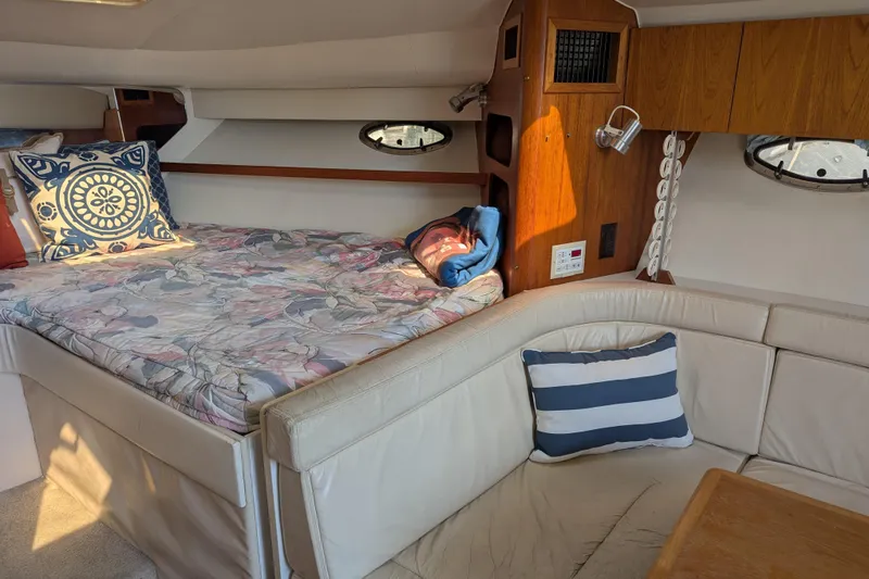 Slide: The Image of 1995 Tiara Yachts 3100 Open cabin interior with bed, cushions, and wooden cabinetry. - 28
