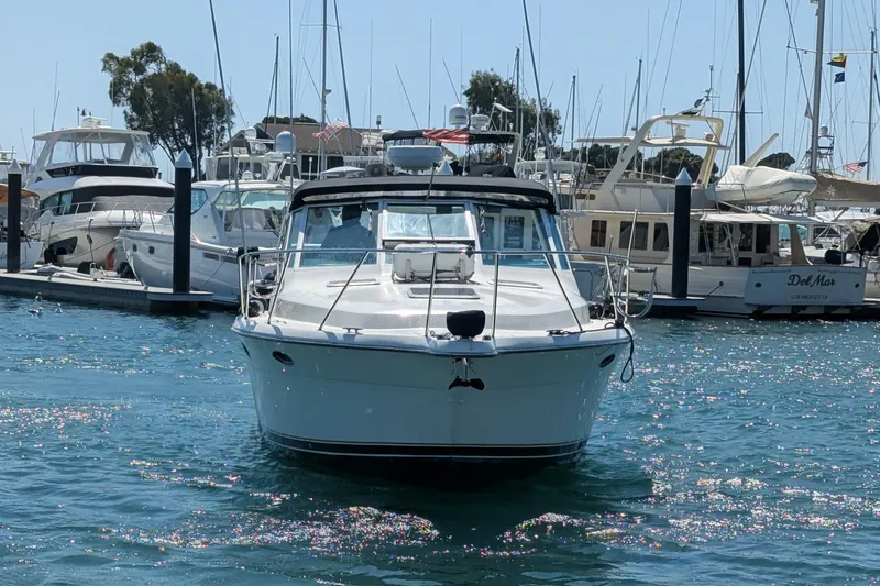 Slide: The Image of 1995 Tiara Yachts 3100 Open docked in a marina, surrounded by other boats. - 3
