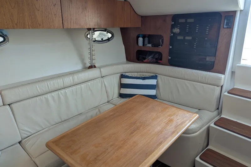 Slide: The Image of Interior of 1995 Tiara Yachts 3100 Open with leather seating and wooden table. - 30