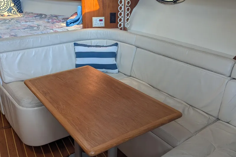 Slide: The Image of 1995 Tiara Yachts 3100 Open interior with white seating and wooden table. - 31