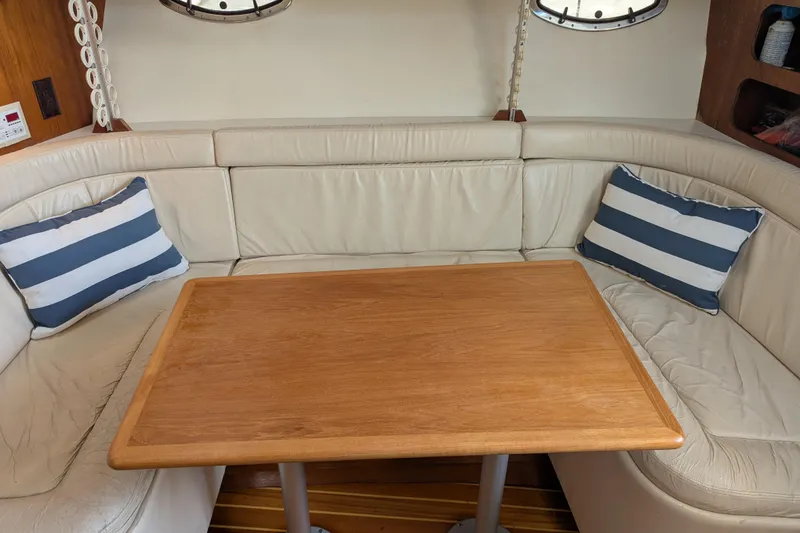 Slide: The Image of Interior of 1995 Tiara Yachts 3100 Open with wooden table and striped cushions. - 32