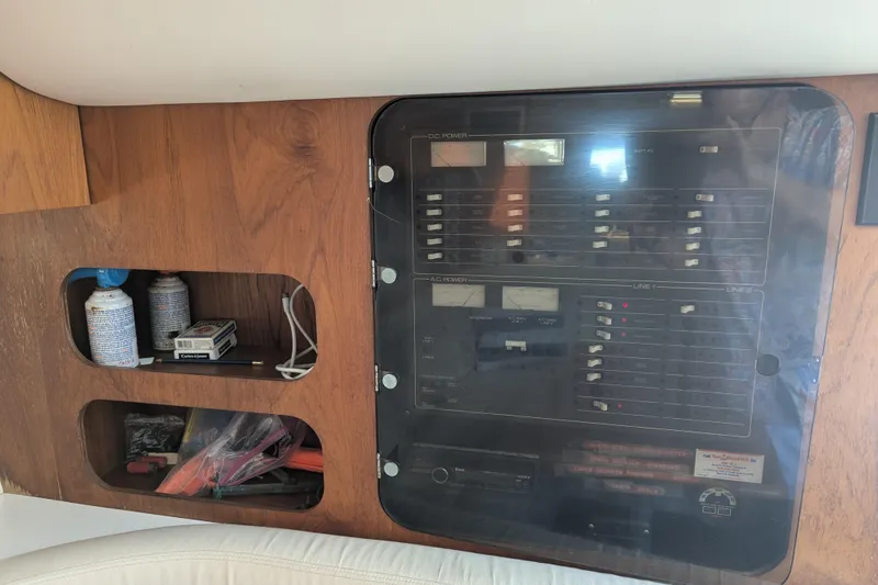 Slide: The Image of 1995 Tiara Yachts 3100 Open electrical panel with storage compartments. - 34
