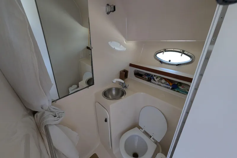 Slide: The Image of 1995 Tiara Yachts 3100 Open bathroom with sink, toilet, and porthole window. - 39