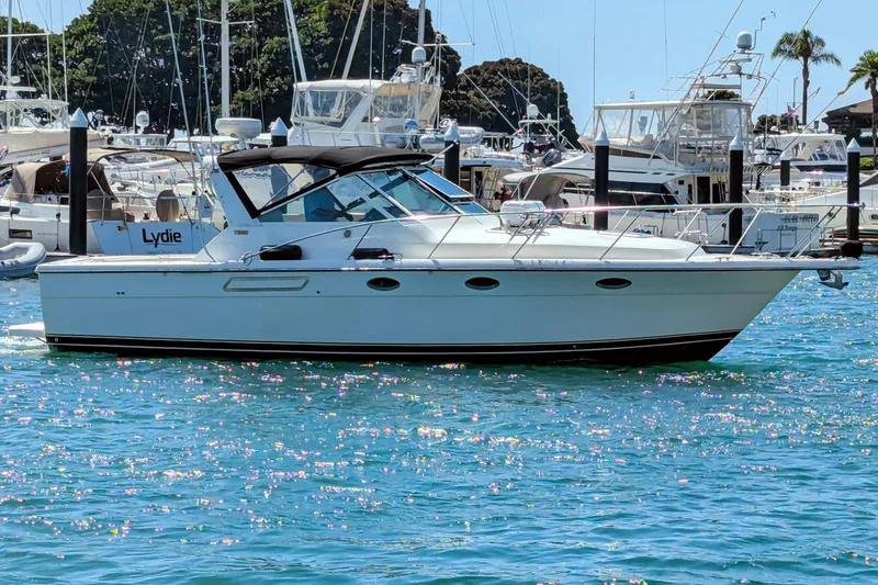 Slide: The Image of 1995 Tiara Yachts 3100 Open in marina, surrounded by other boats, under clear blue sky. - 4