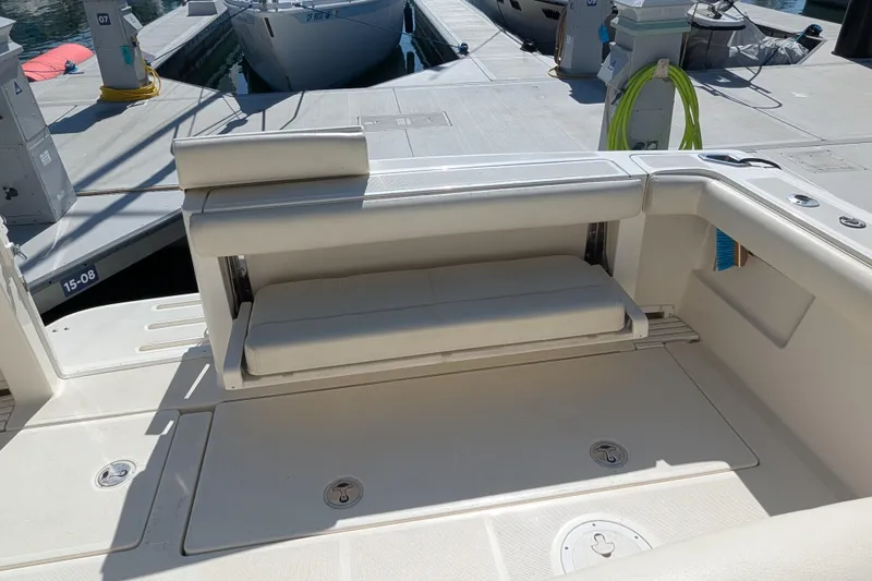 Slide: The Image of 1995 Tiara Yachts Tiara 3100 boat seating area at dock, featuring foldable bench seat. - 41