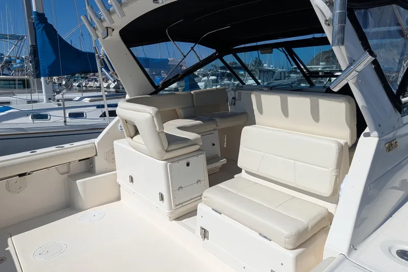Slide: The Image of 1995 Tiara Yachts 3100 interior with white seating, docked at marina. - 42