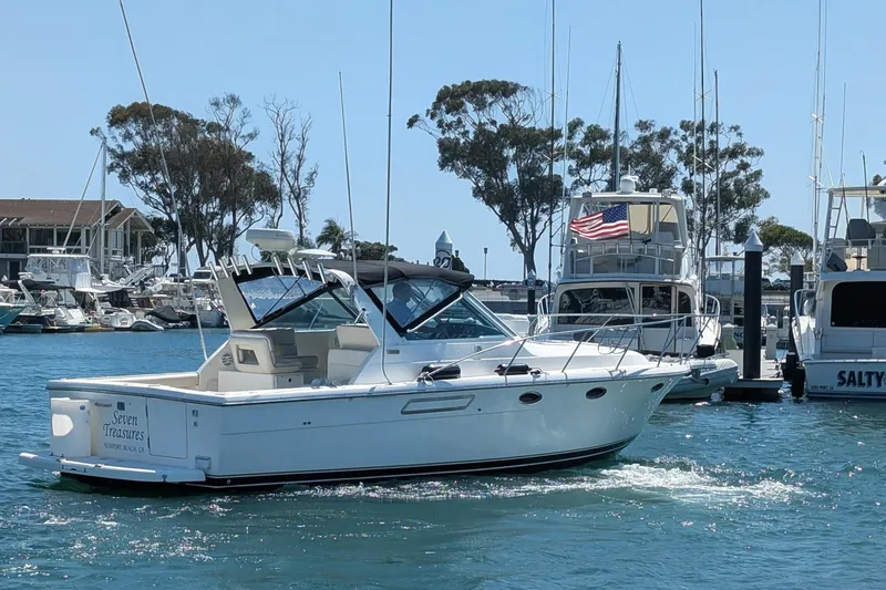 Slide: The Image of 1995 Tiara Yachts 3100 Open cruising in a marina, surrounded by other boats. - 7