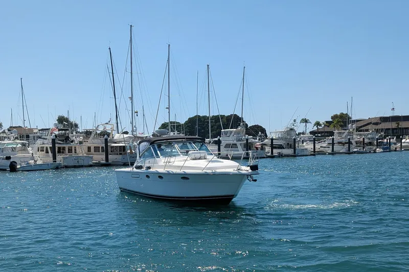 Slide: The Image of 1995 Tiara Yachts 3100 Open cruising in a marina with sailboats in the background. - 8
