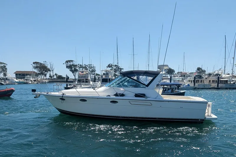 Slide: The Image of 1995 Tiara Yachts 3100 Open boat on water, surrounded by marina and sailboats. - 9