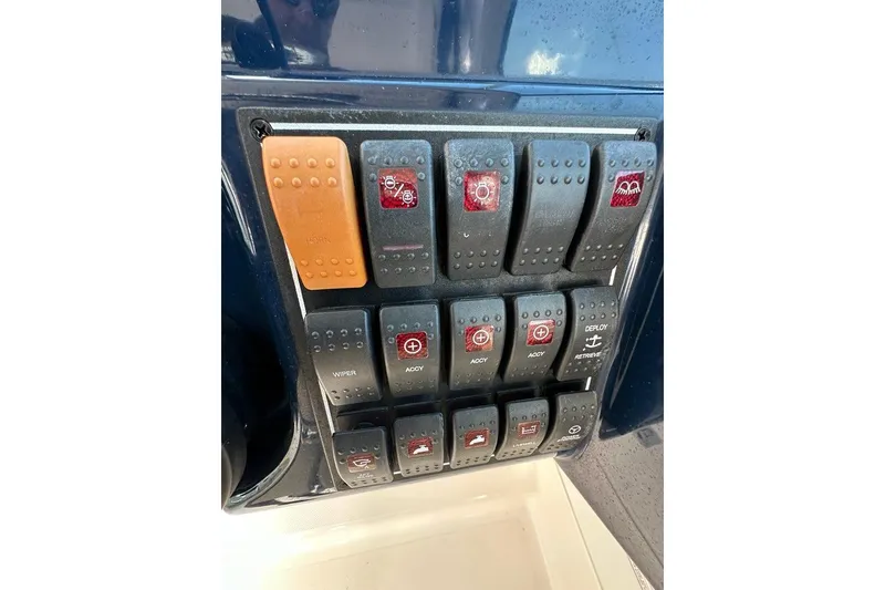 Slide: The Image of Control panel of a 2016 Pursuit DC 265 Dual Console boat with various switches. - 12