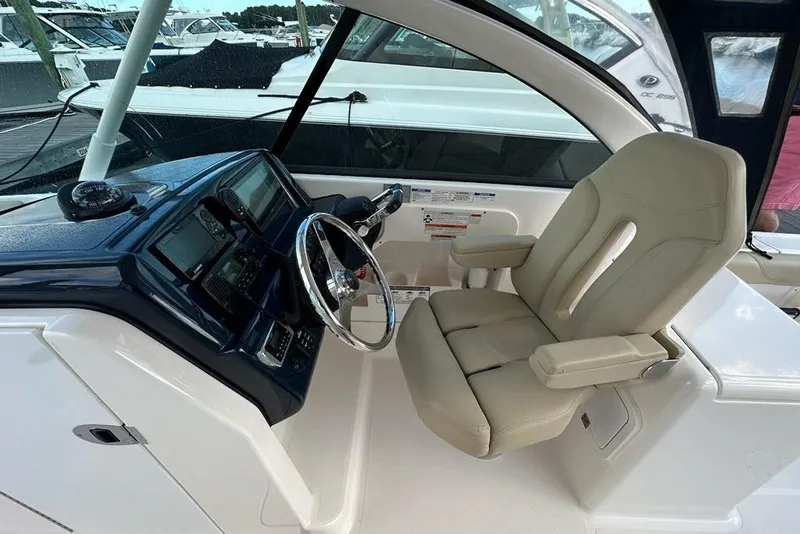 Slide: The Image of 2016 Pursuit DC 265 Dual Console boat interior with steering wheel and captain's chair. - 13