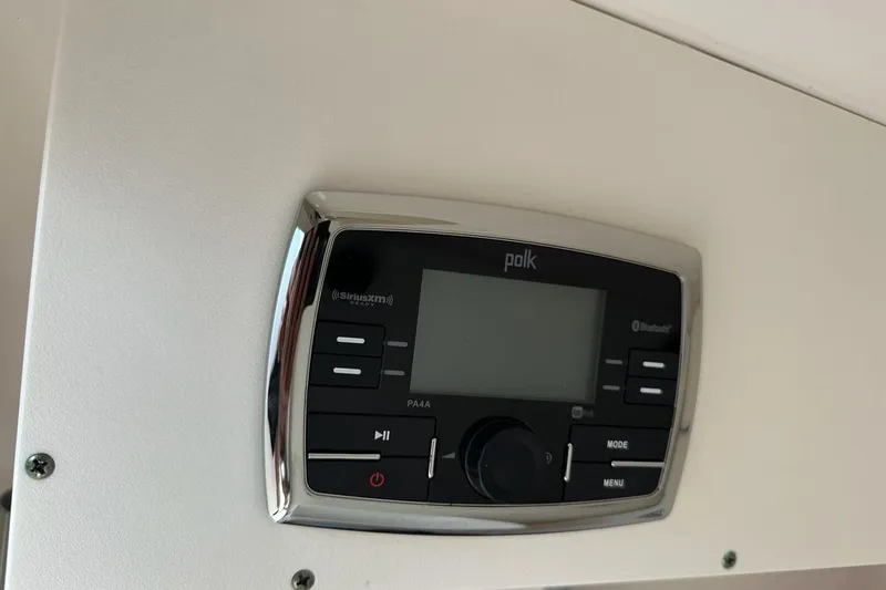 Slide: The Image of Polk audio system on 2016 Pursuit DC 265 Dual Console boat dashboard. - 17