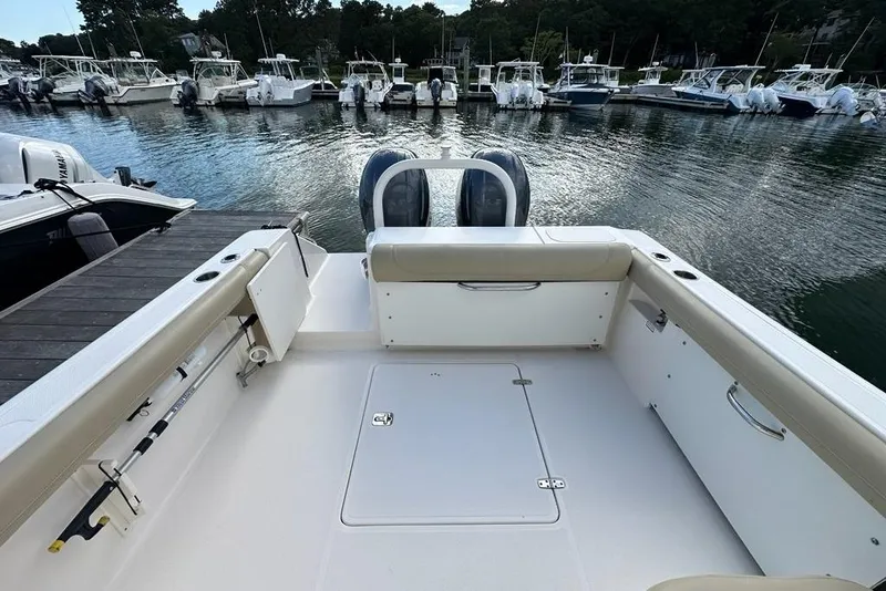 Slide: The Image of 2016 Pursuit DC 265 Dual Console boat docked at marina, spacious seating area. - 19