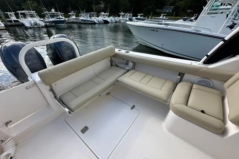 Slide: The Image of 2016 Pursuit DC 265 Dual Console boat interior with beige seating, docked near other boats. - 20