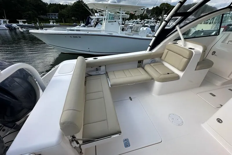 Slide: The Image of 2016 Pursuit DC 265 Dual Console boat interior with beige seating and sleek design. - 21