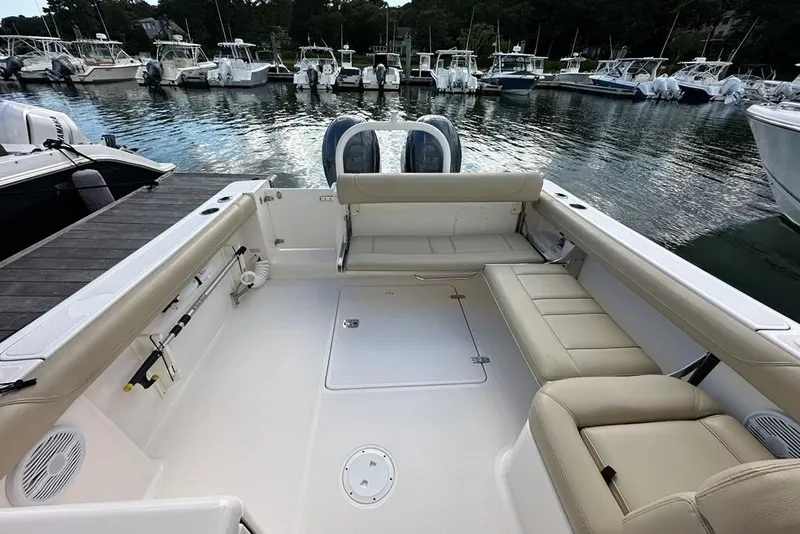 Slide: The Image of 2016 Pursuit DC 265 Dual Console boat interior with seating, docked in marina. - 22