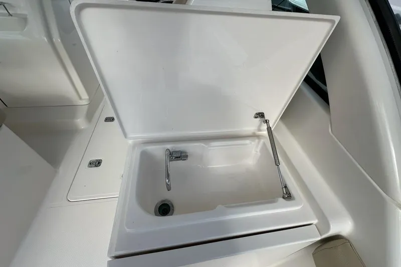 Slide: The Image of Open storage compartment on 2016 Pursuit DC 265 Dual Console boat. - 23