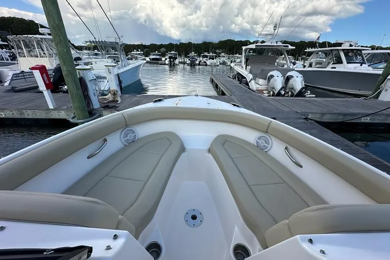 Slide: The Image of 2016 Pursuit DC 265 Dual Console boat docked at marina, featuring spacious seating and scenic view. - 25