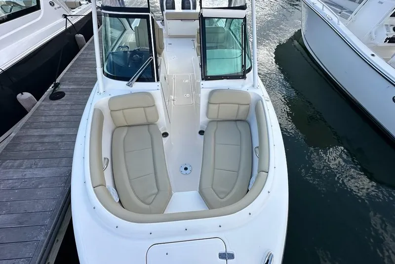 Slide: The Image of 2016 Pursuit DC 265 Dual Console boat with beige seating, docked beside other boats. - 26