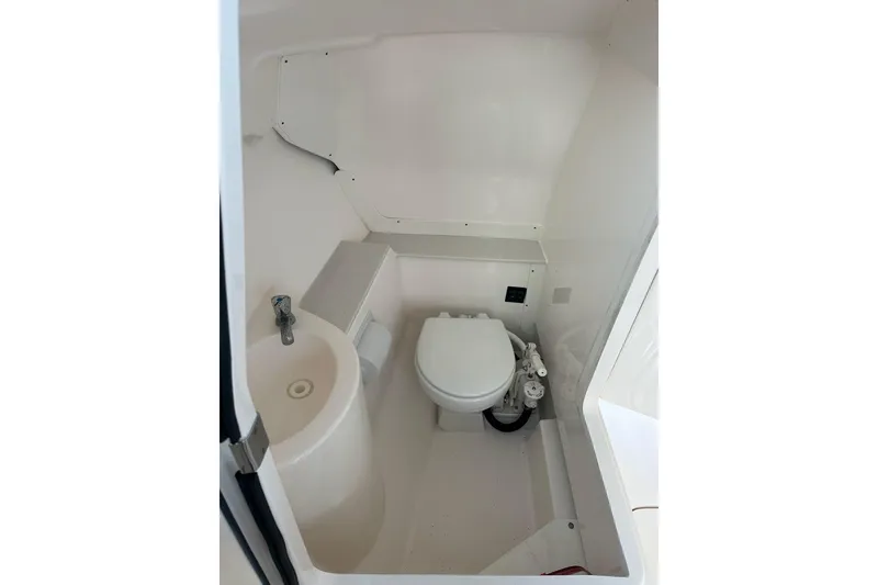 Slide: The Image of 2016 Pursuit DC 265 Dual Console boat interior bathroom with toilet and sink. - 28