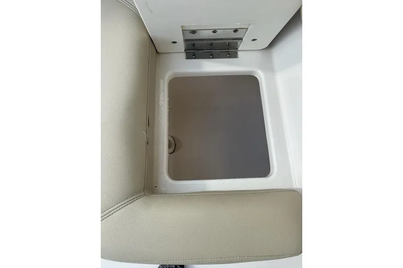 Slide: The Image of Storage compartment in 2016 Pursuit DC 265 Dual Console boat, featuring beige upholstery. - 32