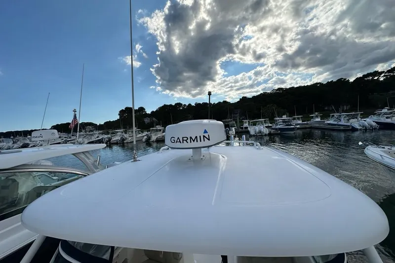 Slide: The Image of 2016 Pursuit DC 265 Dual Console boat with Garmin equipment, docked under a cloudy sky. - 34