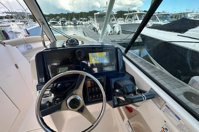 Slide: The Image of 2016 Pursuit DC 265 Dual Console boat dashboard with steering wheel and navigation system. - 9
