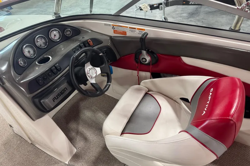 Slide: The Image of 2012 Rinker Captiva 216 BR boat interior with steering wheel and dashboard controls. - 10