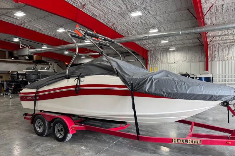 Slide: The Image of 2012 Rinker Captiva 216 BR boat on red trailer in indoor storage. - 12
