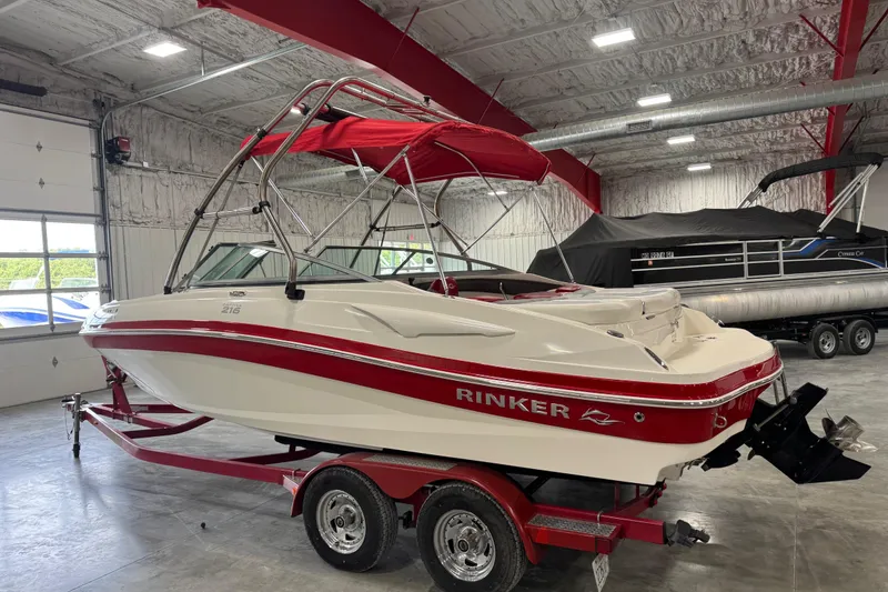 Slide: The Image of 2012 Rinker Captiva 216 BR boat with red accents in a garage setting. - 3