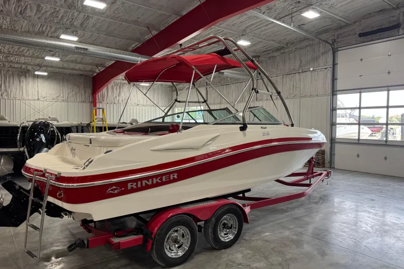 Slide: The Image of 2012 Rinker Captiva 216 BR boat in a garage, red and white design, on a trailer. - 4