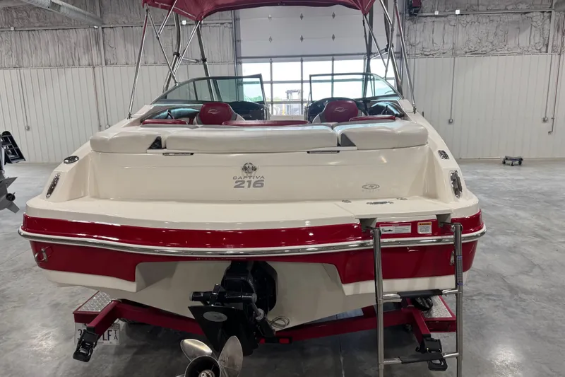 Slide: The Image of 2012 Rinker Captiva 216 BR boat in a garage, rear view with red accents. - 5