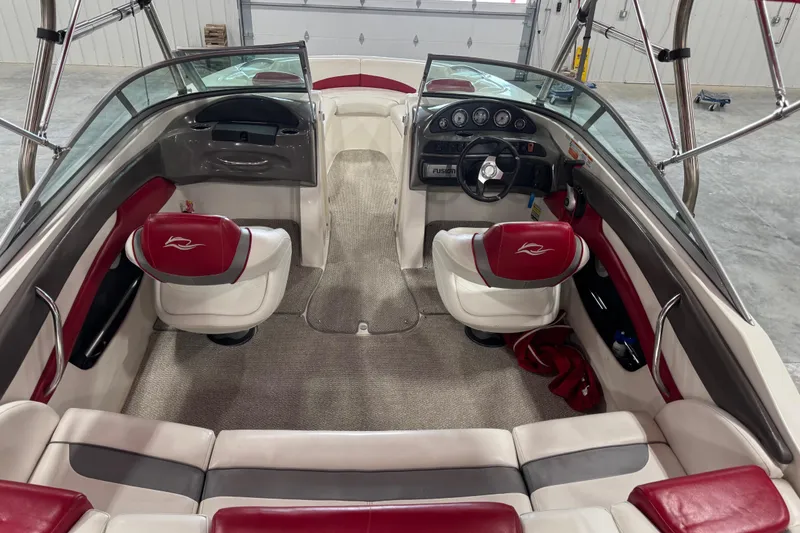 Slide: The Image of 2012 Rinker Captiva 216 BR boat interior with red and white seating, steering wheel, and dashboard. - 6