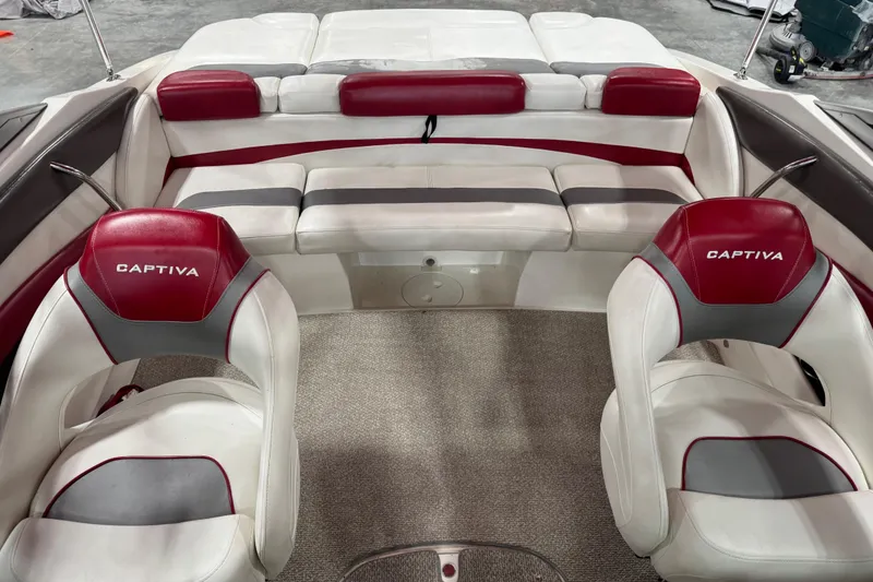 Slide: The Image of 2012 Rinker Captiva 216 BR boat interior with red and white seating, carpeted floor. - 7