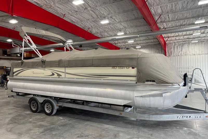 Slide: The Image of 2006 Bennington 2575 RL I/O pontoon boat covered on trailer in indoor storage. - 14