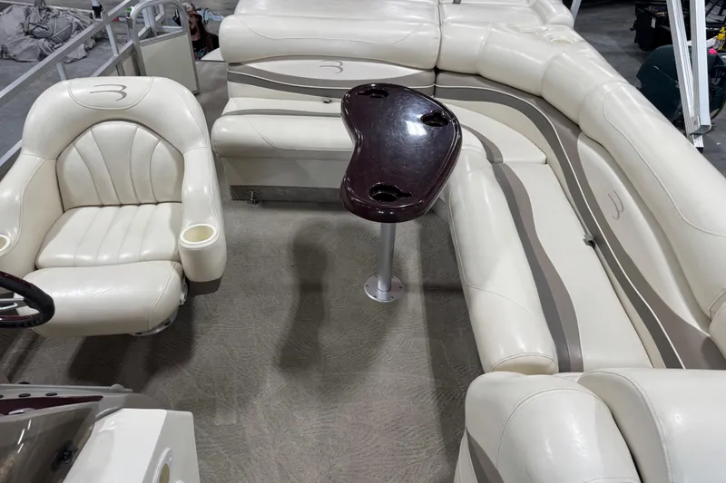 Slide: The Image of 2006 Bennington 2575 RL I/O boat interior with cream seating and a central table. - 9