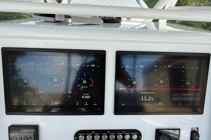 Slide: The Image of 2024 Yellowfin 34 Offshore boat dashboard with dual screens and chrome steering wheel. - 20